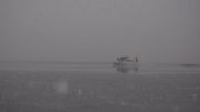 Image of a floatplane taxiing through the Thorne Bay during a snowstorm.