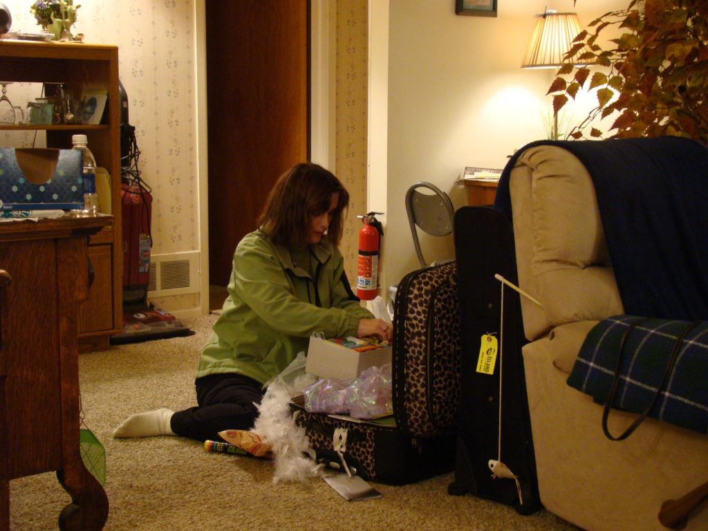 Melissa sits on the floor packing her luggage.