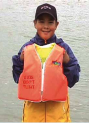 10-year-old Radar Lambert holds a Kids Don't Float life jacket