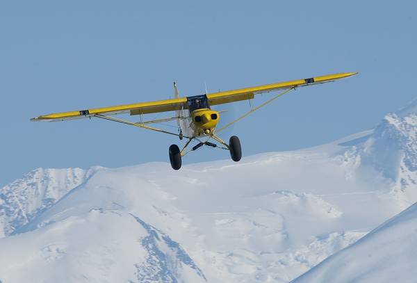 Larry Kaniut flying in his yellow plane